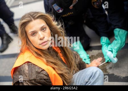 Wien, Österreich. 19. Mai 2023 Klimaaktivistin der Gruppe Last Generation Austria 'Letzte Generation Österreich' Anja Windl mit Sekundenkleber auf der Straße Stockfoto