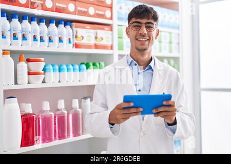 Junger hispanic-Mann Apotheker mit Touchpad in der Apotheke arbeiten Stockfoto