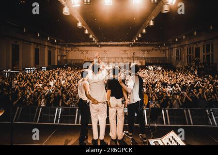 Eine Gruppe männlicher Musiker versammelt sich auf der Bühne zu einem lebhaften Konzert Stockfoto