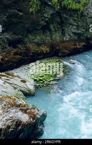 Aare-Schlucht in der Schweiz. Es ist eine malerische alpine Schlucht mit einem blasstürkisblauen Fluss, der durch sie fließt. Stockfoto