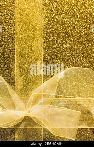 Präsentieren Sie die goldene Papierhülle mit einer Schleife – für den Hintergrund und für Kopien Stockfoto