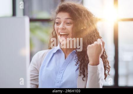 Expressive junge Frau offen Mund Überprüfung Rabatte für Online-Shopping sitzen am Desktop . Stockfoto