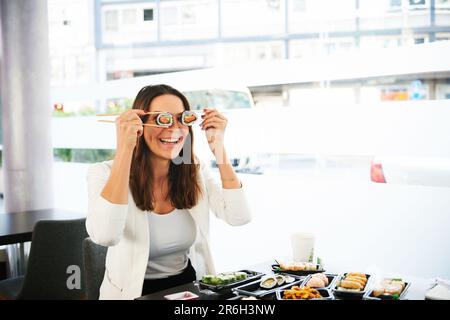 Junge Frau isst Geschäftsessen im Sushi-Restaurant Stockfoto