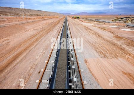 Mineralien, die auf einem langen Förderband in einer Kupfermine transportiert werden. Stockfoto