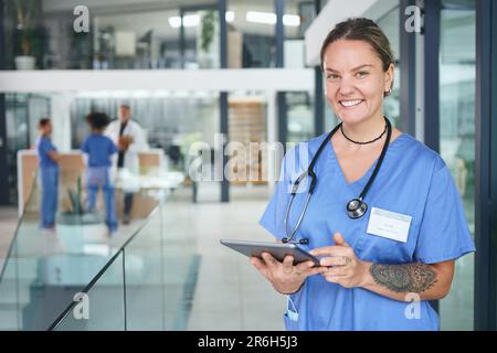 Nicht alle Helden tragen Umhänge, manche tragen Peelings. Gekürztes Porträt einer attraktiven jungen Krankenschwester im Stehen und mit einem digitalen Tablet in der Klinik. Stockfoto