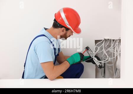 Elektriker mit schraubendrehbarem Patchpanel im Innenbereich Stockfoto