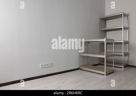 Büroraum mit weißen Wänden und Lagerregalen aus Metall. Platz für Text Stockfoto