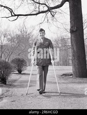 1940S MANN VERWUNDETER VETERAN IN UNIFORM, DER LÄCHELT UND MIT KRÜCKEN IN DIE KAMERA SCHAUT – M3273 HAR001 HARS-INSPIRATION MÄNNCHEN ZU VERTRAUEN B&W TRAURIGKEIT AUGENKONTAKT FREIHEIT MEERESTRÄUME GLÜCK FRÖHLICH GLOBALE STÄRKE HEILUNG MUT FÜHRUNG WELTKRIEGE STOLZ WELTKRIEG 2. WELTKRIEG 2. WELTKRIEG MARINES LÄCHELN UNIFORMEN MIT VERWUNDETEN, FREUDIGEN VETERANEN, WELTKRIEG 2 JUNGER ERWACHSENER MANN SCHWARZ-WEISS WEISSE ETHNISCHE HERKUNFT HAR001 ALTMODISCH Stockfoto