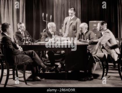 1930S SECHS MÄNNER, EINER STEHT IN EINEM ERNSTHAFTEN GESCHÄFTSTREFFEN IM BÜRO DES BOSS MIT GROSSEN FESTNETZTELEFONEN UND SCHREIBTISCHSET - O623 HAR001 HARS TEAMWORK WETTBEWERBSINFORMATIONEN LIFESTYLE FÜNF 5 STUDIO AUFNAHME ENTSCHEIDUNG 6 MANAGER KOPIERBEREICH HALBE LÄNGE PERSONEN MÄNNER RISKIEREN SECHS UNTERNEHMENSBERUFE SENIOR MAN EXECUTIVE SETZT SENIOR ERWACHSENE B&W MITTLEREN ALTERS MÄNNER TORE ANZUG UND KRAWATTE BESCHÄFTIGUNGSDOKUMENTE STRATEGIE KARRIERE FÜHRUNG LOW-ANGLE-INNOVATION CHANCE BEHÖRDE CEO-TÄTIGKEITEN CHEFS VERBINDUNG DREI TEILE PASSEN KONZEPTIONELLE TELEFONE STILVOLL BETREUER, KEINE WEIBLICHE PAPIERARBEIT Stockfoto