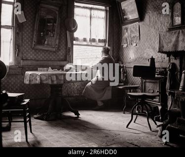 1920S 1930S SENIORIN, DIE AUS DEM FENSTER DES MIETSHAUSES AUF MAULBEERSTRASSE-ARMUT-SLUM SCHAUT, BEDINGUNGEN NEW YORK CITY, USA - Q41932 CPC001 HARS PRIVATLEBEN VEREINIGTE STAATEN KOPIERRAUM HALBE LÄNGE FRAUEN VEREINIGTE STAATEN VON AMERIKA RISIKO SENIOR ERWACHSENER B&W TRAURIGKEIT NORDAMERIKA SENIORIN NORDAMERIKANISCHE TRÄUME ALTER ALTER ALTER ALTER ALTER ALTER ALTER ALTER BEDINGUNGEN RÜCKANSICHT VON AUF ALTER NYC-ÄLTERE VON HINTER NEW YORK CITIES BENACHTEILIGTEN NEW YORK CITY MIETSHAUS ANONYME RÜCKBLICK ENTTÄUSCHTE ENTTÄUSCHTES, UNTRENNBARES VERARMTES SLUM SCHWARZ-WEISS WEISS WEISS WEISS, ETHNISCHE ZUGEHÖRIGKEIT VERZWEIFELT, ALTMODISCHE ABNUTZUNG Stockfoto