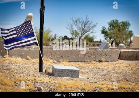 Eine dünne blaue Linie für die Unterstützung der Strafverfolgung fliegt auf dem Concordia Cemetery in El Paso, Texas, über ein Grab. Stockfoto