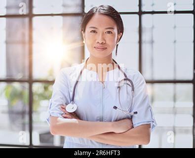asiatischer Arzt mit gekreuzten Armen im Krankenhaus Stockfoto