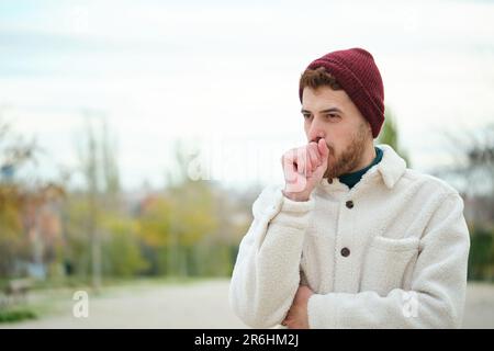 Lateinischer junger Mann hustet im Winter, Grippe. Stockfoto