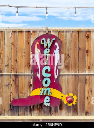 Kaktusblume, spanischer Glockenturm, Orgelgebirge, Feuerhydrant, Stucksäulen und Schatten, Cowboy Boot Willkommensschild Stockfoto