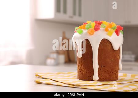 Köstlicher Osterkuchen mit kandierten Früchten auf einem weißen Tisch in der Küche. Platz für Text Stockfoto