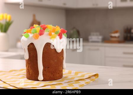 Köstlicher Osterkuchen mit kandierten Früchten auf einem weißen Tisch in der Küche. Platz für Text Stockfoto
