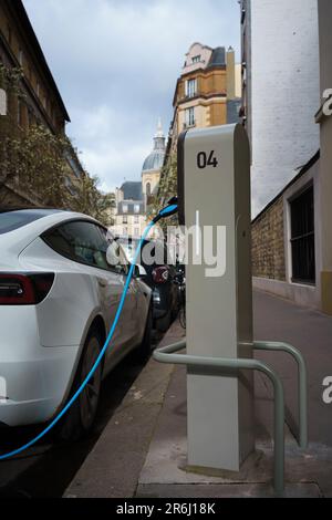 Elektroauto an der EV-Ladestation in der Straße von Paris, Frankreich. Stockfoto