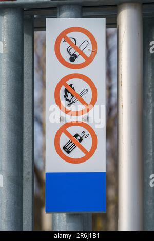 Rauchverbotsschilder, offene Flammen oder Handys in der Tankstelle, Nahaufnahme. Stockfoto