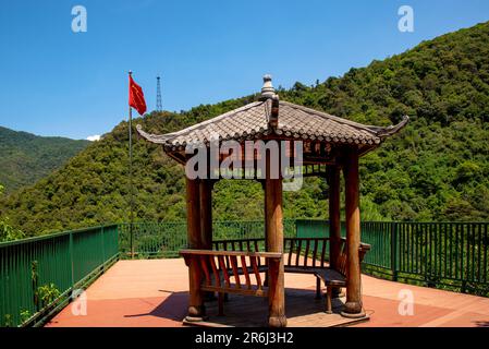 XICHANG, CHINA - 30. MAI 2023 - Hinter dem Vollmond-Pavillon am malerischen Xichang Satellite Launch Center in Xich Fliegt Eine chinesische Nationalflagge Stockfoto