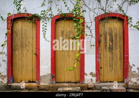 Fassade mit drei typischen bunten Türen und hängenden Pflanzen in der UNESCO-Weltkulturerbestätte Paraty, Brasilien Stockfoto