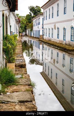 Überflutete die enge Straße bei Flut mit Reflexionen von kolonialen Häusern in der historischen Stadt Paraty, Brasilien, UNESCO-Weltkulturerbe Stockfoto