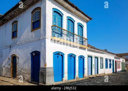 Typisch koloniale zweistöckige Häuser mit bunten Türen und Fenstern an sonnigen Tagen in der historischen Stadt Paraty, Brasilien, UNESCO-Weltkulturerbe Stockfoto