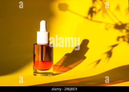Glaskosmetikbehälter mit Serum zur Gesichts- und Körperpflege auf gelbem Hintergrund. Kosmetik für Frauen. Weibliches Schönheitswerkzeug und Kosmetik. Face se Stockfoto