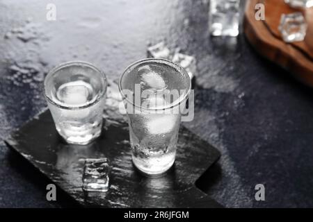 Gehen Sie an Bord mit Wodka-Shots auf einem dunklen Tisch Stockfoto