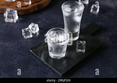 Gehen Sie an Bord mit Wodka-Shots auf einem dunklen Tisch Stockfoto