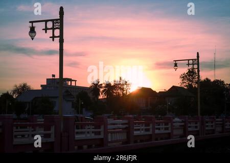 Herrlicher Sonnenuntergang auf der Promenade mit Palmen und Laternen. Stockfoto