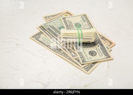 Dollar-Banknoten mit Gummiband auf grauem Grunge-Hintergrund Stockfoto