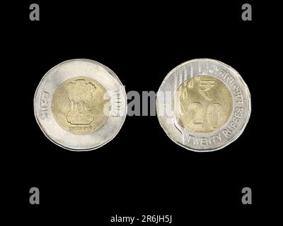 Die Vervollständigung einer alten indischen 20-Dollar-Rupien-Münze aus Gold und silberfarbenem Metall, isoliert auf schwarzem Hintergrund, auf der Vorder- und Rückseite Stockfoto