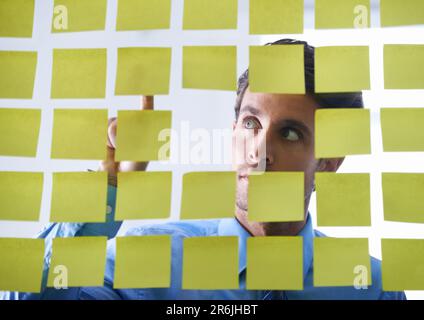 Kreativer Mann, Gesicht und Denken, Zeigen auf Haftnotizen beim Brainstorming oder Planen von Aufgaben auf einer Tafel. Rücksichtsvoller Mann, der nachdenklich ist Stockfoto