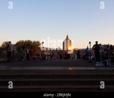 Paris, Frankreich - Juli, 14: Menschen, die am 14. Juli 2022 auf der Pont des Arts Artists Bridge von Paris mit dem Institut de France im Hintergrund spazieren gehen Stockfoto