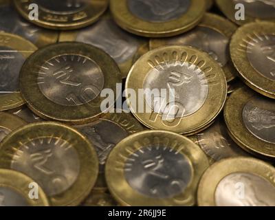 Eine gemischte Sammlung seltener indischer Bimetall-10 (zehn) Rupien-Münzen Gold und Silber in einem Stapel Stockfoto