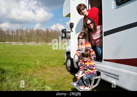 Familienurlaub, RV-Reisen mit Kindern, glückliche Eltern mit Kindern haben Spaß auf der Urlaubsreise im Wohnmobil, Außenansicht des Wohnwagens Stockfoto