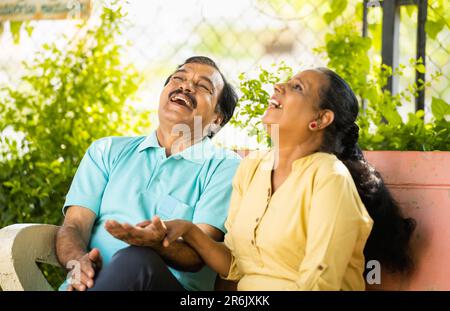 Lachende indische Seniorenpaare, die sich im Park unterhalten - Konzept von Entspannung, Unterhaltung und Lebensstil für den Ruhestand Stockfoto