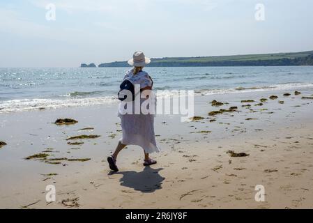 Frau, die im Sommer am Strand spaziert, Knoll Beach, Shell Bay, Studland, Dorset, UK Stockfoto