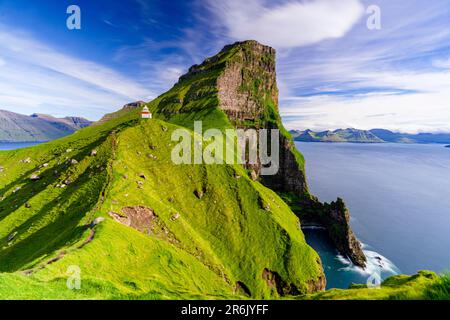 Kallur Leuchtturm auf Klippen mit Gras bedeckt mit Borgarin Berg im Hintergrund, Kalsoy Insel, Färöer Inseln, Dänemark, Europa Stockfoto