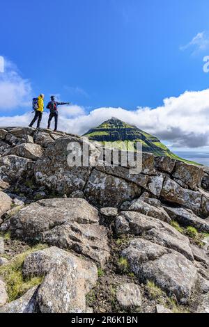 Touristen, die den Fjord während einer Wanderung zum Skaelingsfjall Berg im Sommer, Streymoy Island, Färöer Inseln, Dänemark, Europa beobachten Stockfoto
