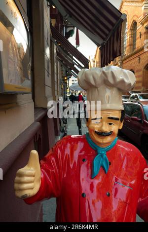 Skulptur eines Küchenchefs mit Daumen nach oben in einem Restaurant in der alten europäischen Stadt Stockfoto