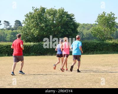 Kesgrave, Suffolk - 10. Juni 2023 : Parkrun an einem heißen, hellen Sommermorgen. Läufer Jung und Alt schnell und langsam, Erwachsene und Kinder. Stockfoto