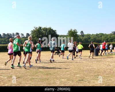 Kesgrave, Suffolk - 10. Juni 2023 : Parkrun an einem heißen, hellen Sommermorgen. Läufer Jung und Alt schnell und langsam, Erwachsene und Kinder. Stockfoto