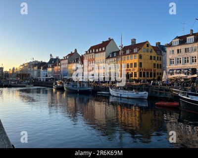 Touristisches Nyhavn bei Sonnenuntergang mit bunten Häusern und Booten Stockfoto