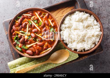 Rajma Masala ist ein beliebtes nordindisches Gericht mit roten Kidney Beans und Reis aus nächster Nähe auf einem Holztablett auf dem Tisch. Horizontale Draufsicht von oben Stockfoto