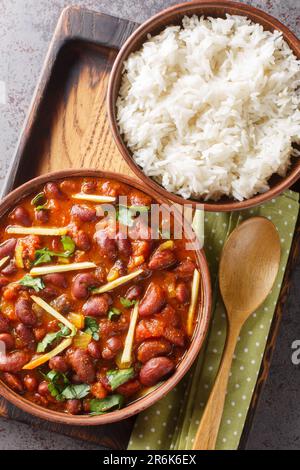 Rajma Masala Red Kidney Beans Curry serviert mit Basmati Reis Nahaufnahme auf einem Holztablett auf dem Tisch. Vertikale Draufsicht von oben Stockfoto