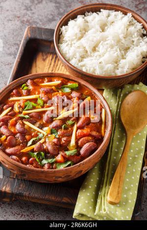 Rajma Masala ist ein indisches vegetarisches Gericht, bestehend aus roten Kidnierenbohnen in einer dicken Soße mit vielen Gewürzen, serviert mit Reis aus der Nähe auf einem hölzernen Tablett o Stockfoto