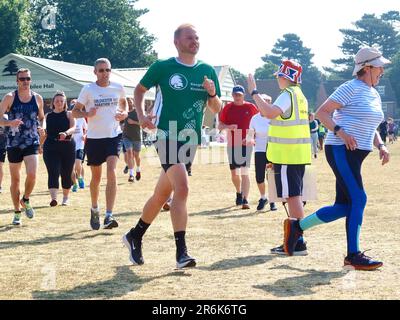 Kesgrave, Suffolk - 10. Juni 2023 : Parkrun an einem heißen, hellen Sommermorgen. Läufer Jung und Alt schnell und langsam, Erwachsene und Kinder. Stockfoto