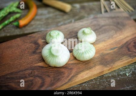 Geschälte frische rohe Zwiebeln auf Holzhintergrund. Stockfoto