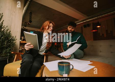 Geschäftsleute arbeiten früh am Morgen an der Café-Bar zusammen an ihrer neuen Marketingstrategie Stockfoto